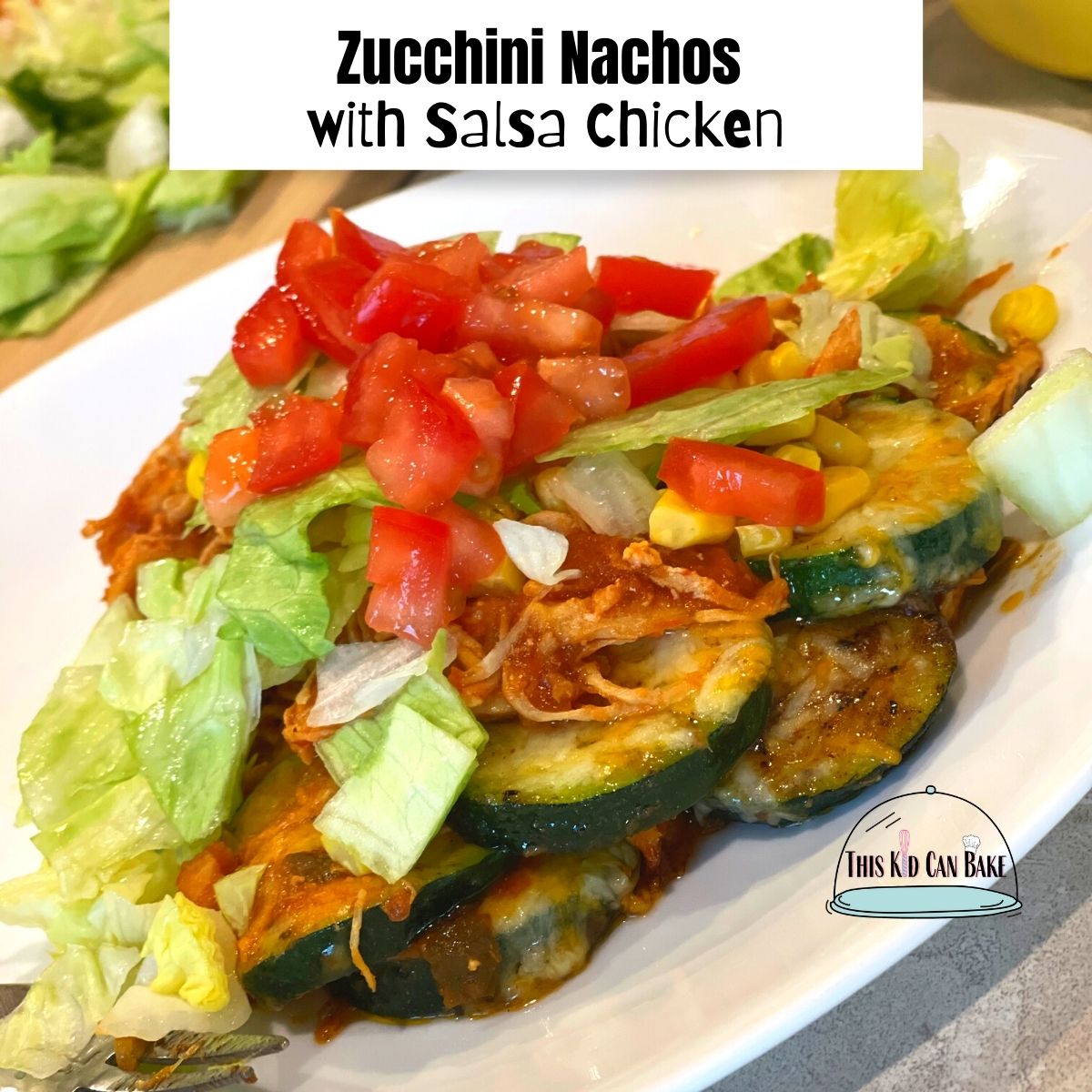 a picture of zucchini nachos topped with shredded chicken, lettuce, tomato, and corn.
